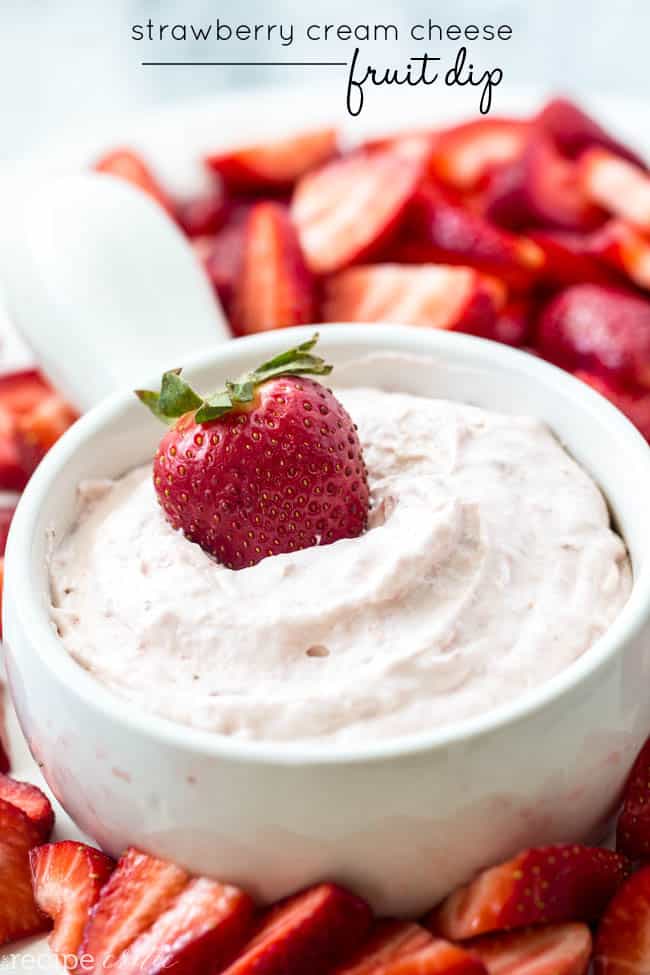 A bowl of cream cheese fruit dip with a strawberry on top.