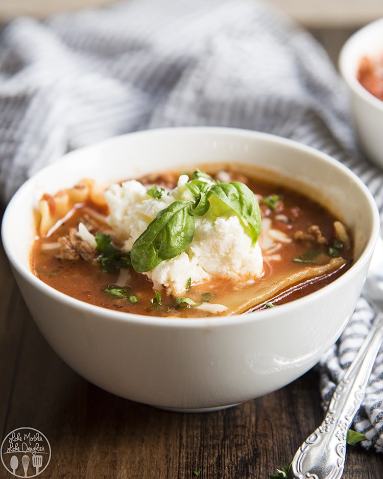 A bowl of lasagna soup with fresh basil on top.