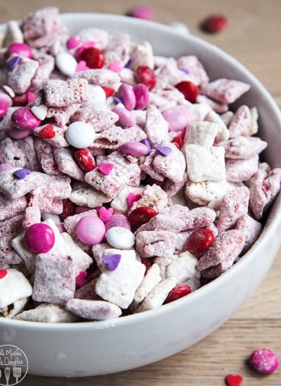 Above shot of valentine's day puppy chow in a bowl with powdered sugar and m&m's.