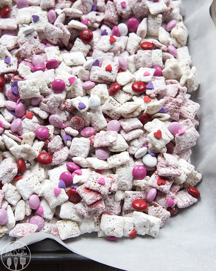 A pan of valentine puppy chow with valentine m&ms and sprinkles. 
