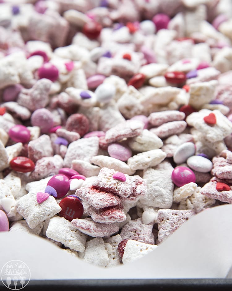 A close up of a white and pink muddy buddy cereal mixture. 