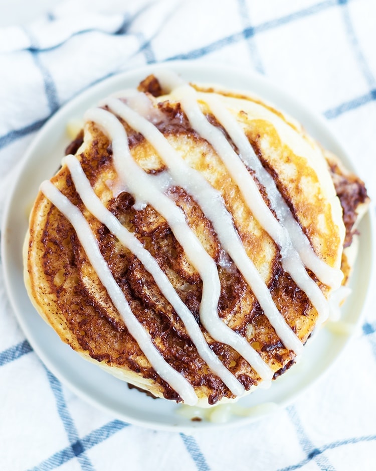 Cinnamon Roll Pancakes with a cinnamon swirl and topped with cream cheese syrup