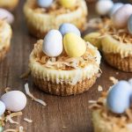 Mini Easter cheesecakes topped with toasted coconut and mini chocolate eggs.