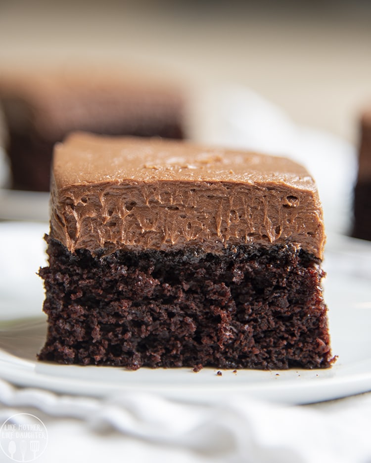 A piece of chocolate cake with a thick chocolate frosting on top.