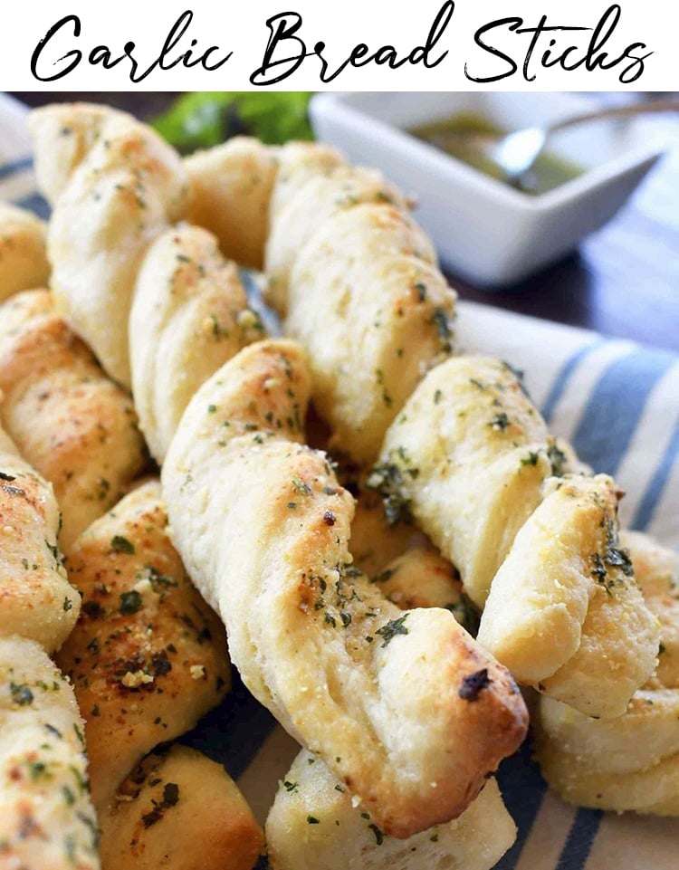 A pile of twisted garlic bread sticks in a basket.