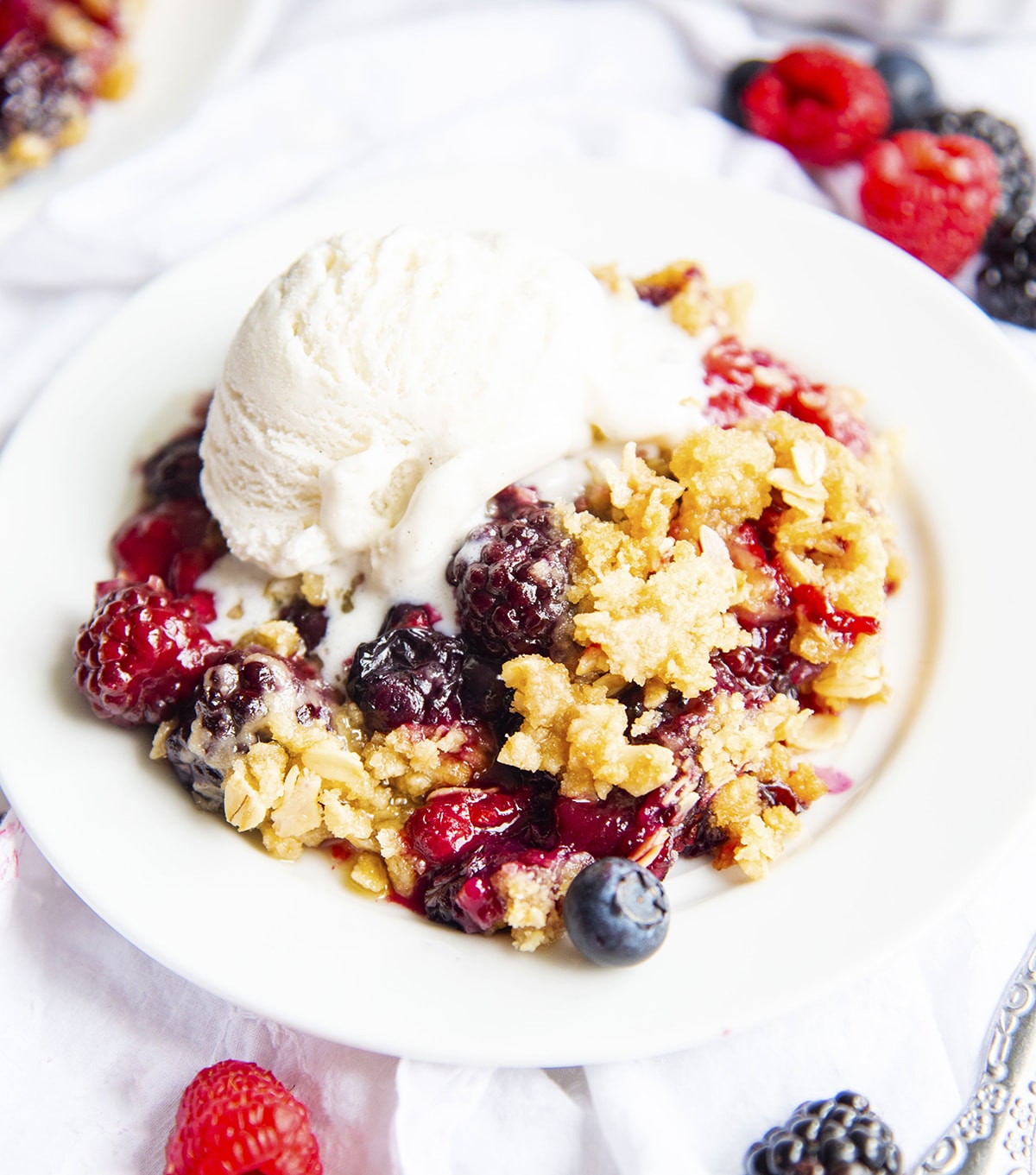 A plate of berry crisp with ice cream.