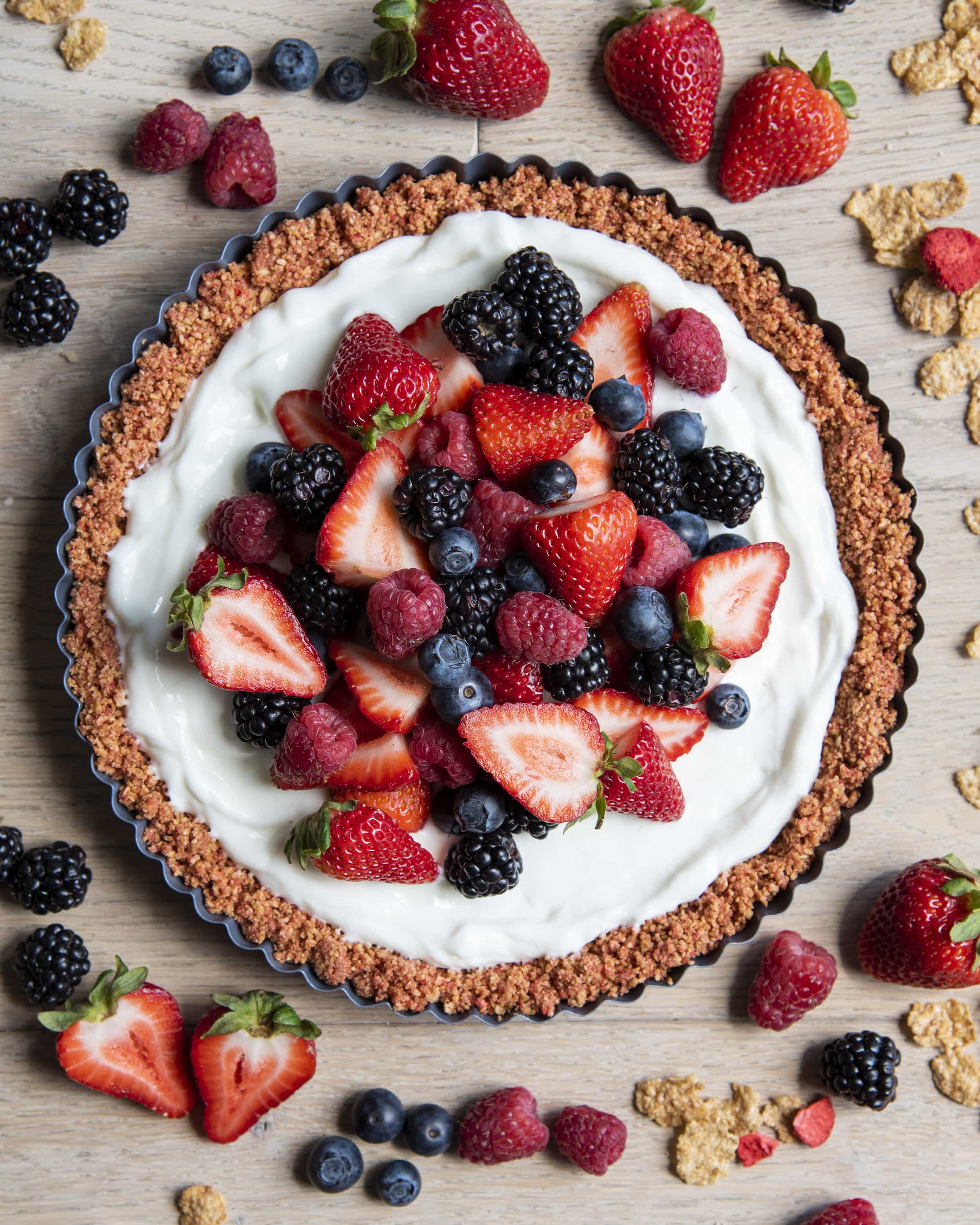 An overhead photo of a no bake yogurt tart topped with fresh berries. 