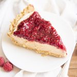 A piece of a peanut butter pie topped with raspberry sauce.
