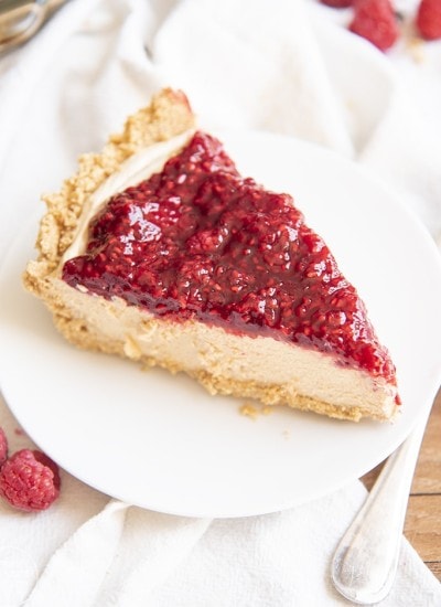 A piece of a peanut butter pie topped with raspberry sauce.