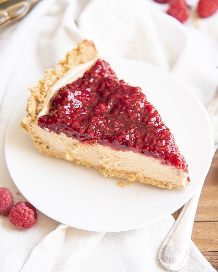 A piece of a peanut butter pie topped with raspberry sauce.