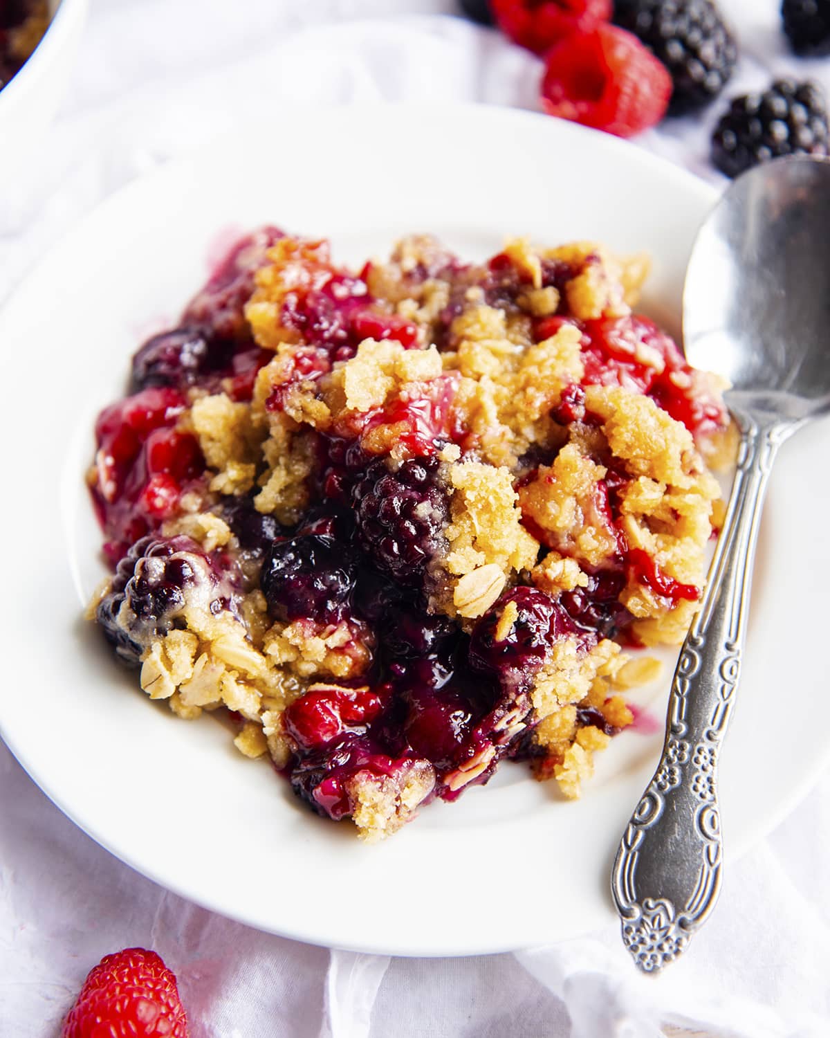 Berry crumble with blackberries, raspberries, and blueberries on a plate.
