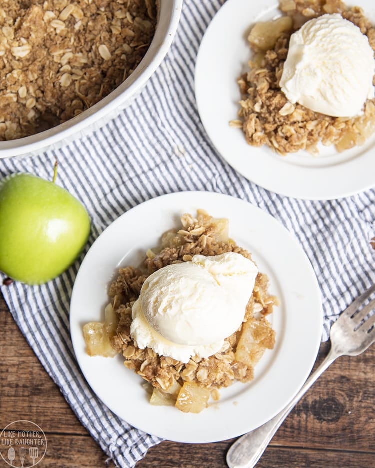 An overhead photo of two plates of apple crisp with ice cream.