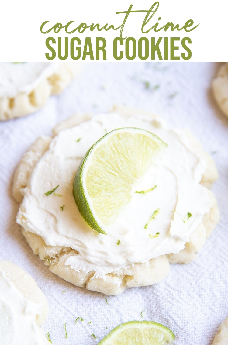 A sugar cookie topped with white frosting, lime zest, and a lime wedge. 
