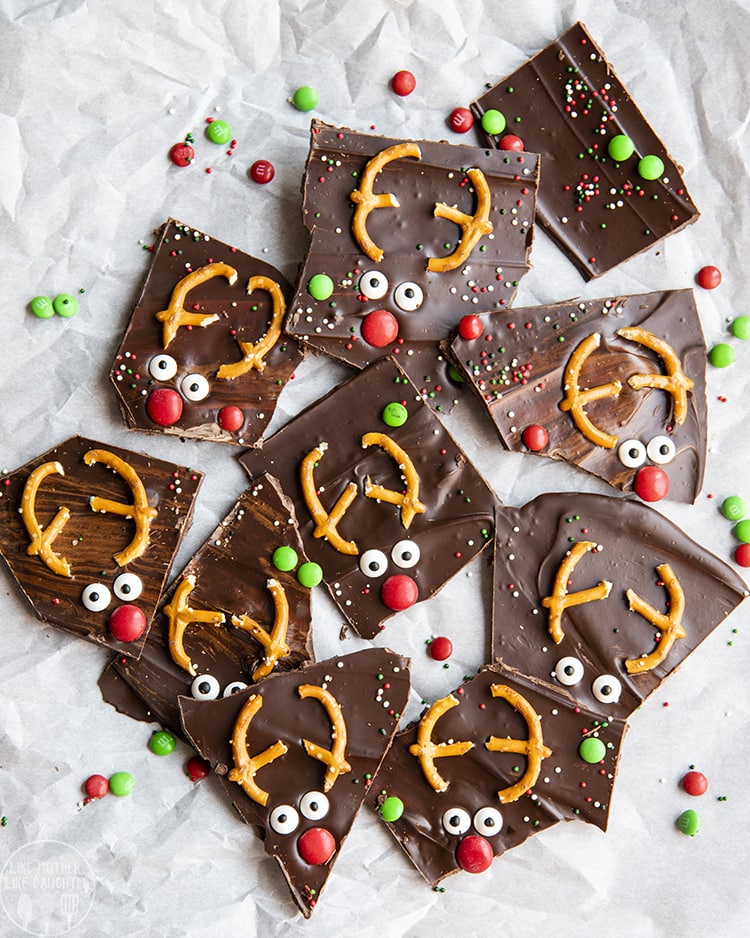 Reindeer Chocolate Bark decorated to look like reindeers with pretzels, candy eyes and m&ms