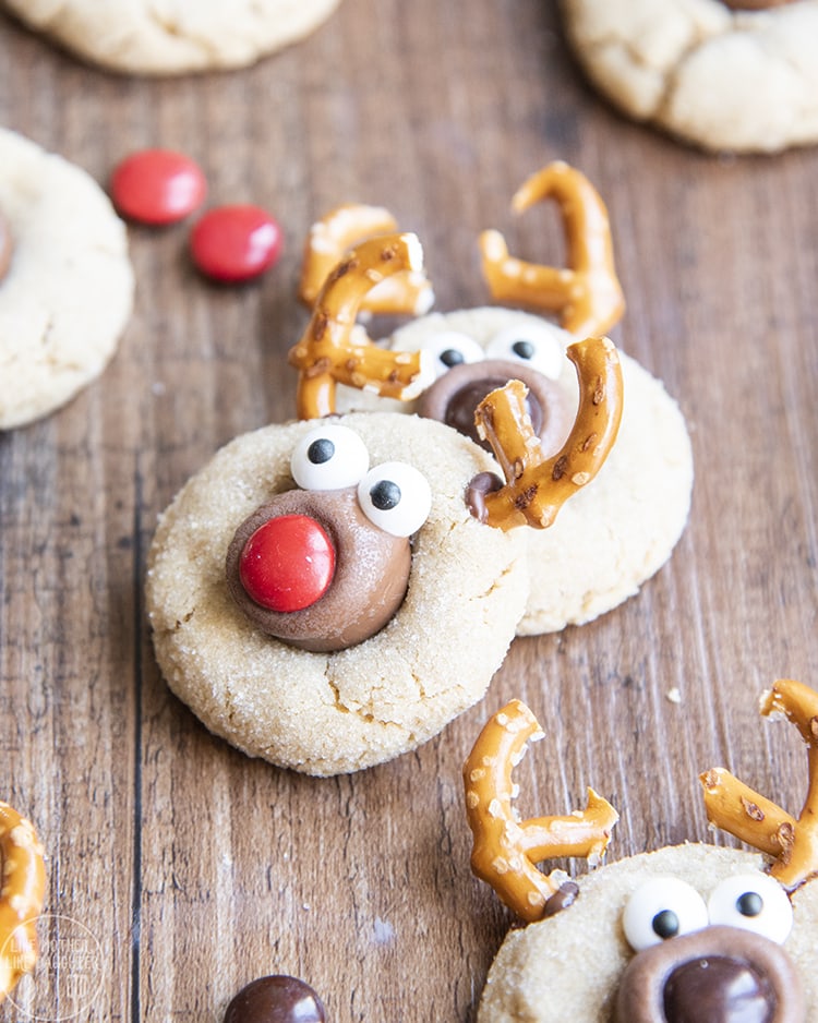 Reindeer Peanut Butter Cookies decorated with pretzels, and candy eyes, and m&m noses to look like reindeer