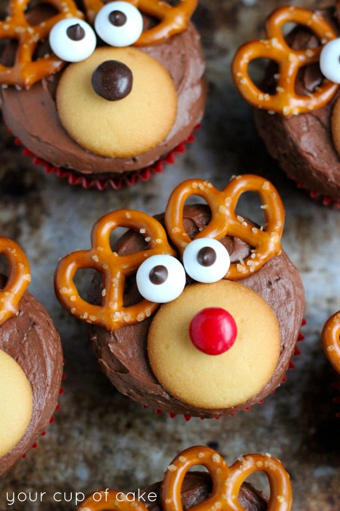 Chocolate cupcakes decorated with pretzels, candy eyes, and m&ms to look like Santa\'s reindeer.