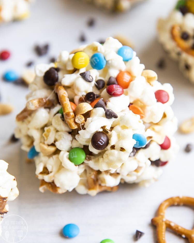 A popcorn ball loaded with pretzels, m&ms, chocolate chips, and peanuts.
