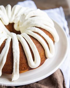 pumpkin bundt cake with cream cheese frosting on a white plate