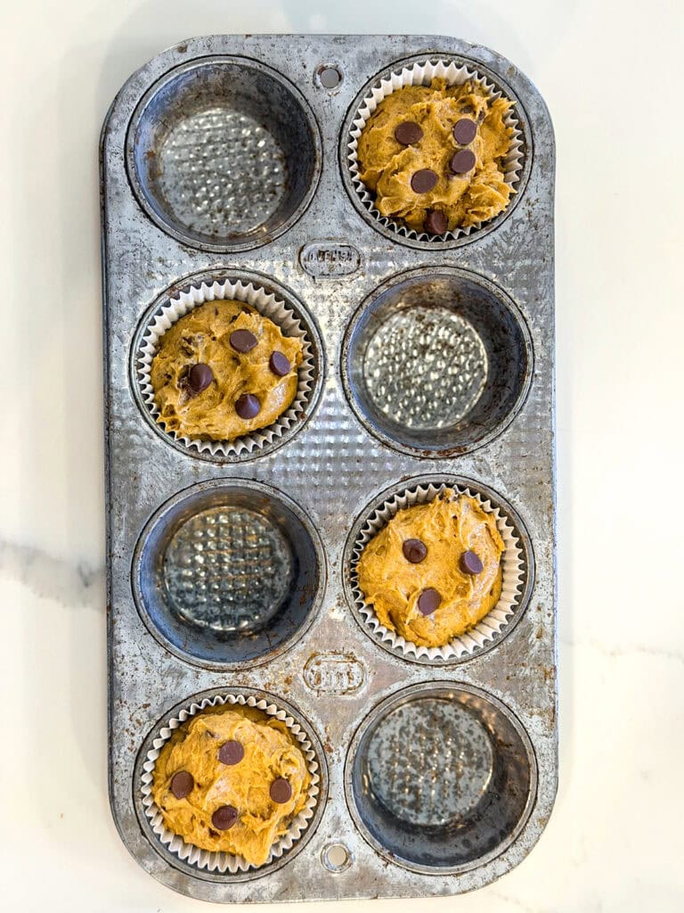 Pumpkin chocolate chip muffin batter in a muffin tin.