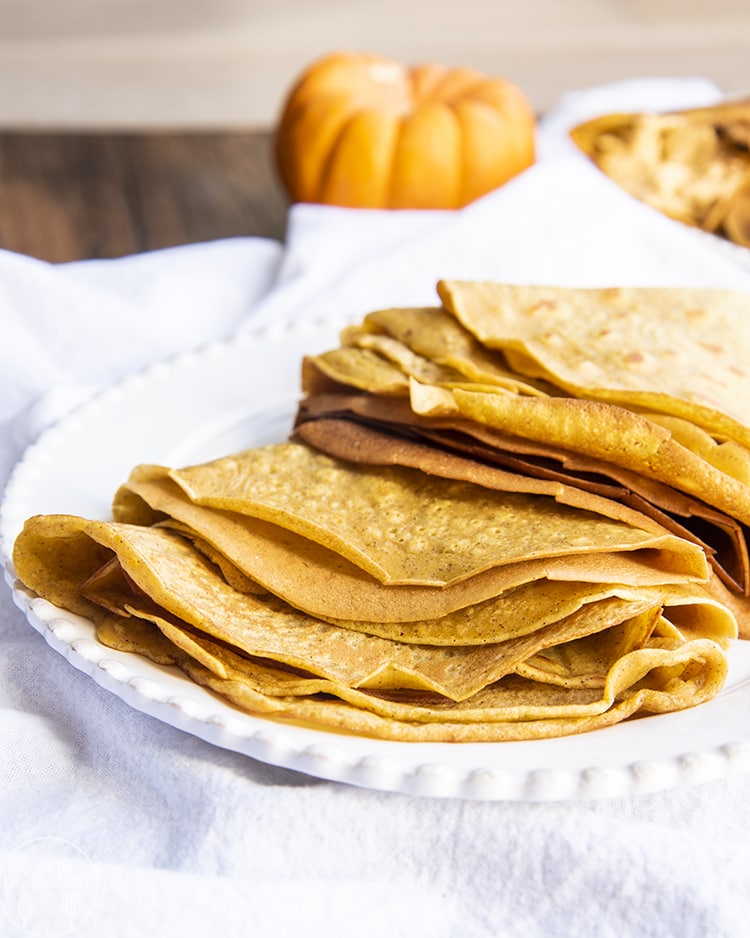 Pumpkin Crepes stacked on a plate and ready to be filled with your favorite crepe fillings