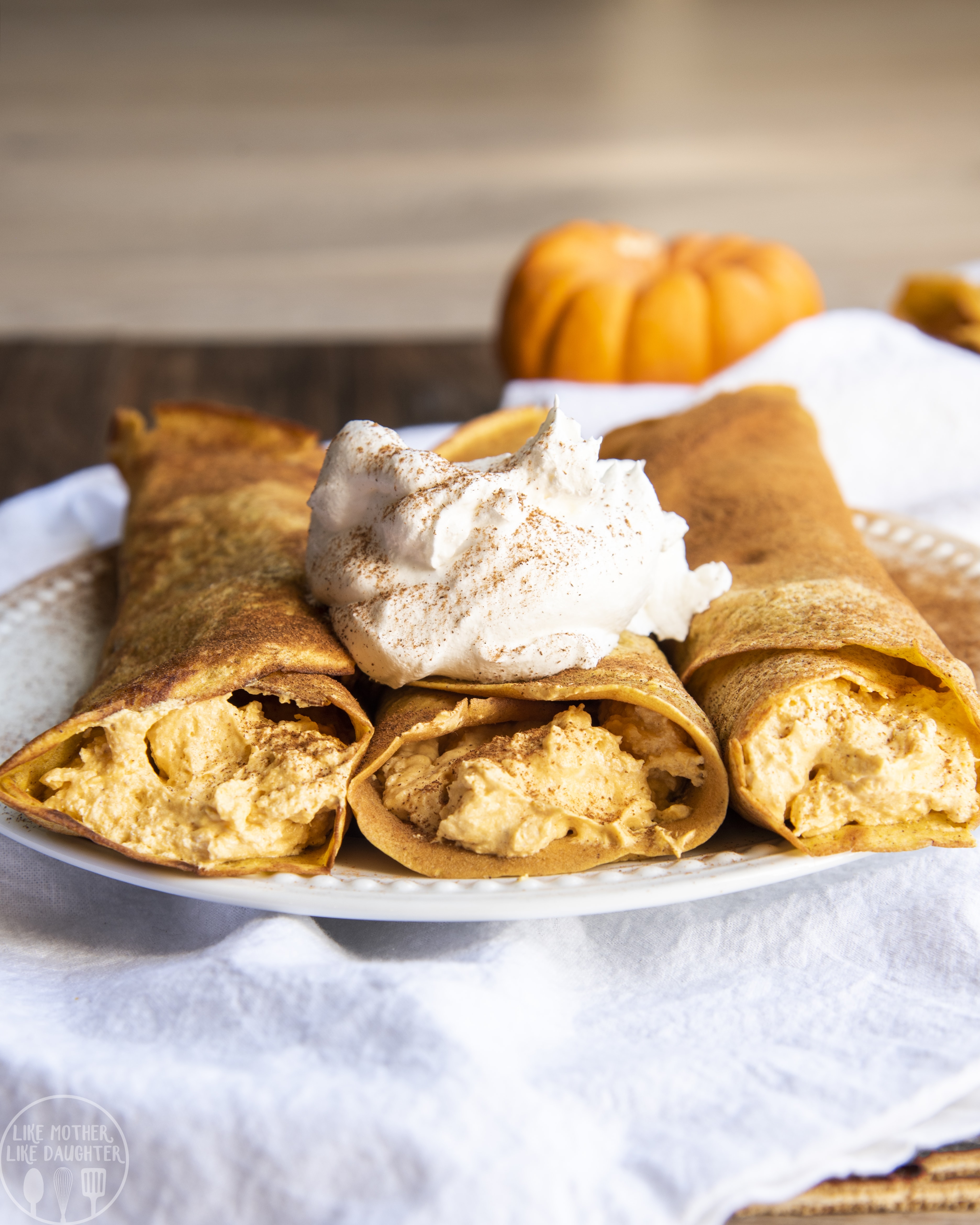 Pumpkin crepes with pumpkin cheesecake filling and topped with whipped cream