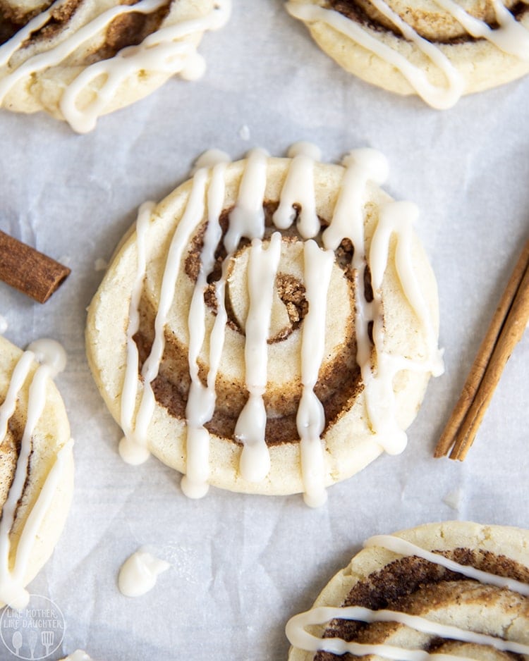 A sugar cookie with a swirl of cinnamon in the middle, and icing drizzled on top.