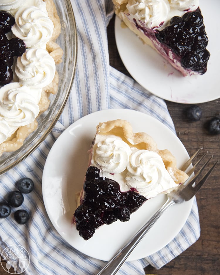 Lemon Sour Cream pie with a creamy lemon custard topped with whipped cream and blueberry sauce