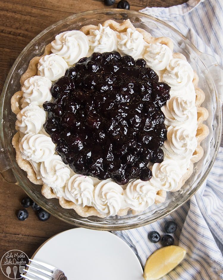 An overhead photo of a pie with whipped cream on the edges, and blueberry sauce in the middle. 