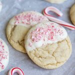 Two sugar cookies dipped in white chocolate, and topped with crushed candy cane pieces.