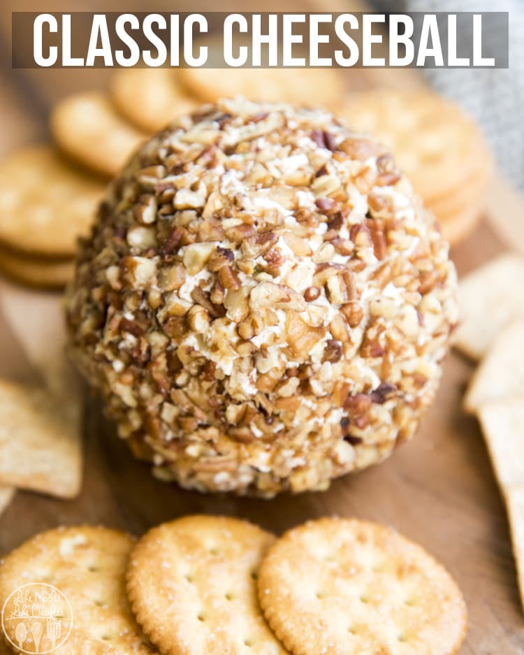 A cheese ball on a wooden board with crackers. 