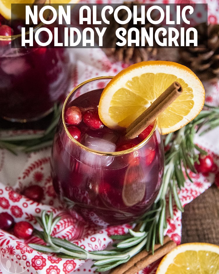 A non alcoholic Christmas sangria in a clear glass with a gold rim. 