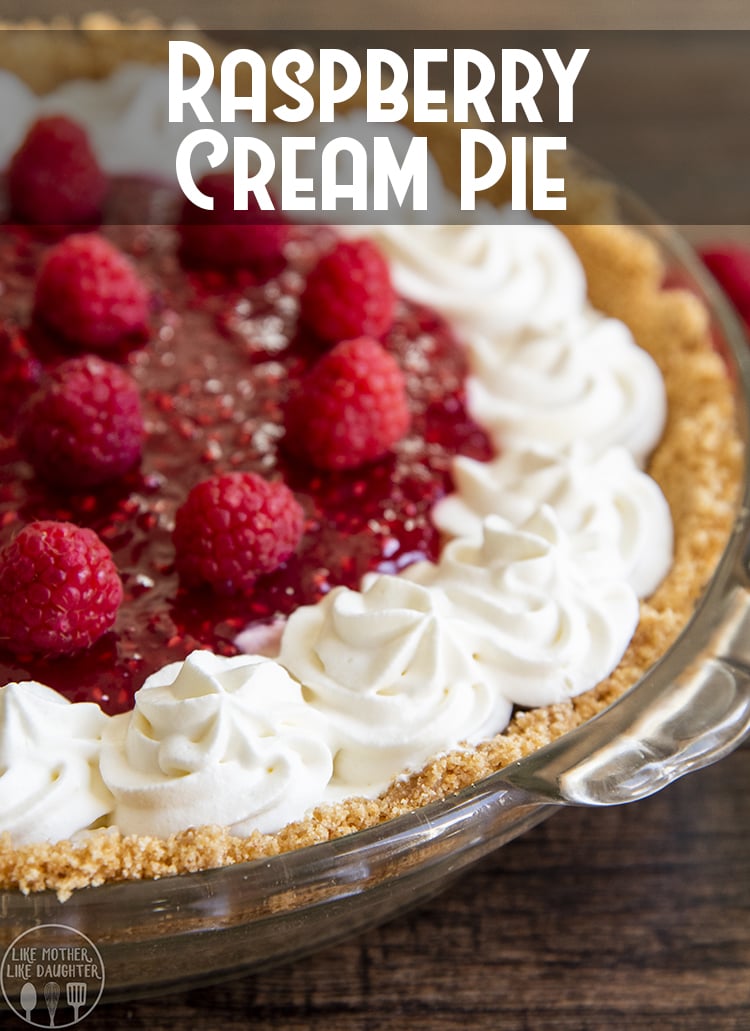 A raspberry cream pie topped with fresh whipped cream and raspberries. 