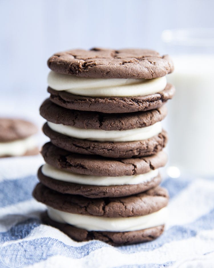 Close-up image of stacked homemade oreos on a blue and white cloth.