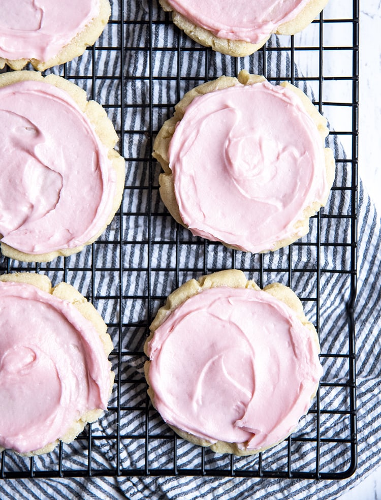 Above image of copycat swig sugar cookies on a cooling rack with pink frosting.