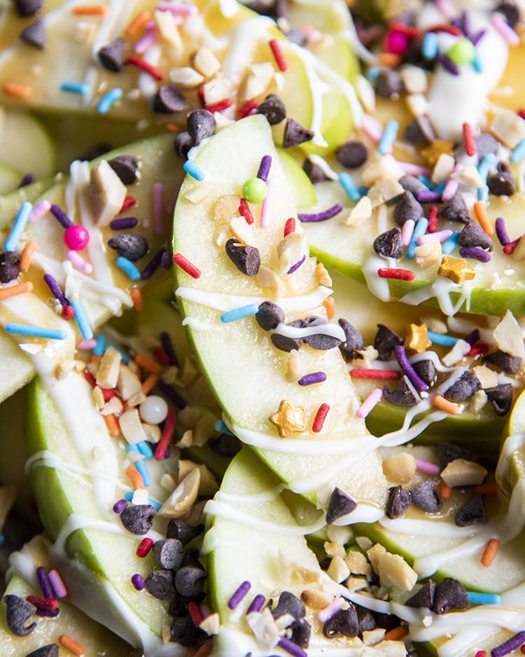 Close up image of apple nachos showing sliced apples with caramel and mini chocolate chips and sprinkles.