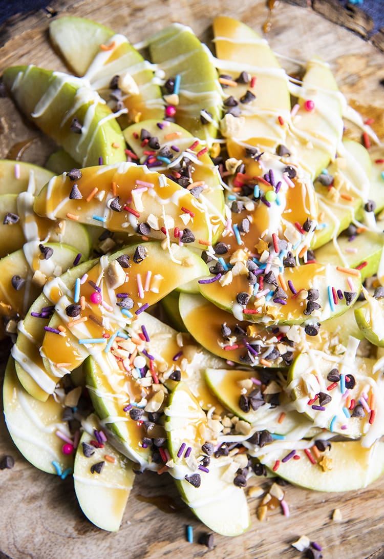 Apple slices topped with caramel, chocolate, and sprinkles