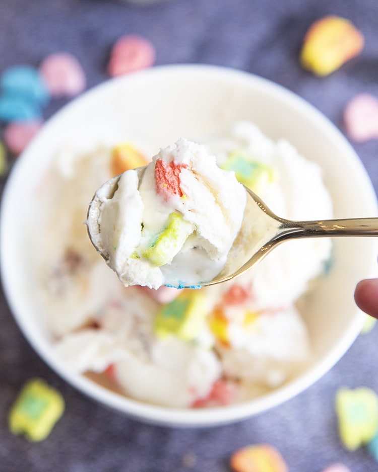 Close up image of a spoon filled with lucky charms cereal milk ice cream.