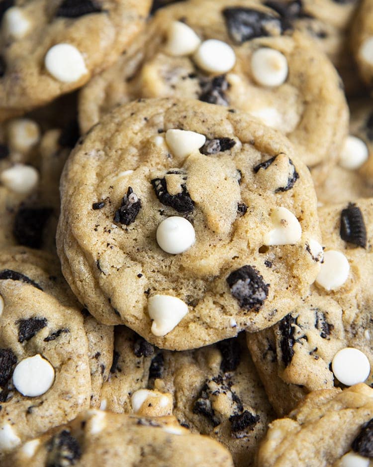 Close-up image of cookies and cream cookies with cookie pieces and white chocolate chips.