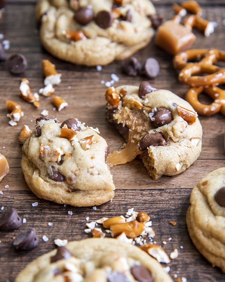 Gooey caramel coming out of a salted caramel pretzel chocolate chip cookie
