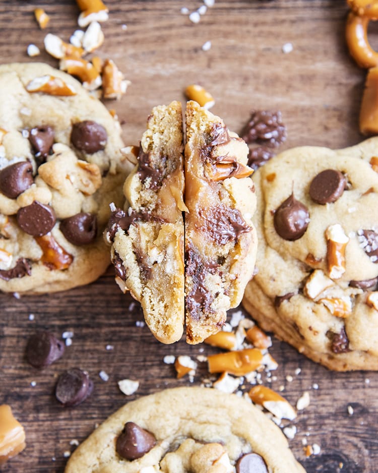 Gooey caramel inside a chocolate chip cookie with sea salt, shown on its side