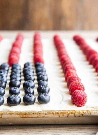 A white cake with blueberries and raspberries making a flag cake