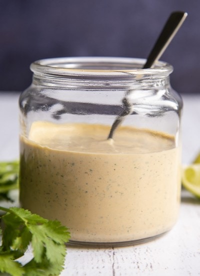 Chipotle Ranch Dressing in a clear glass jar with a spoon