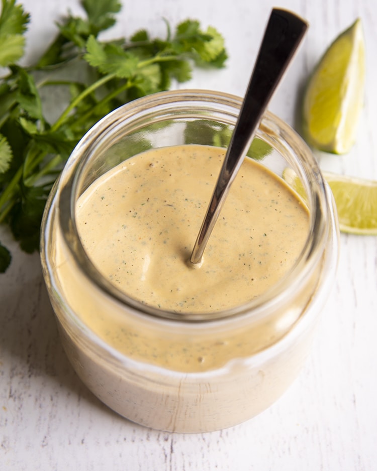 Chipotle Ranch dressing in a jar with a spoon in the middle
