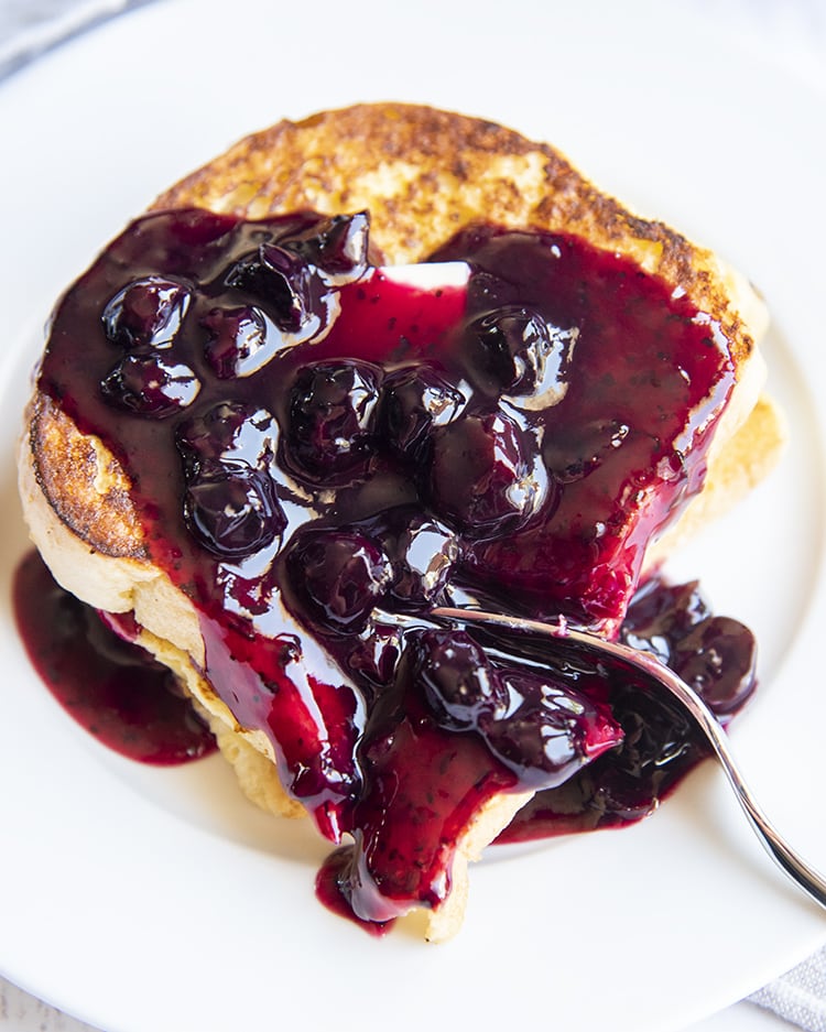 Blueberry Sauce on top of french toast on a white plate