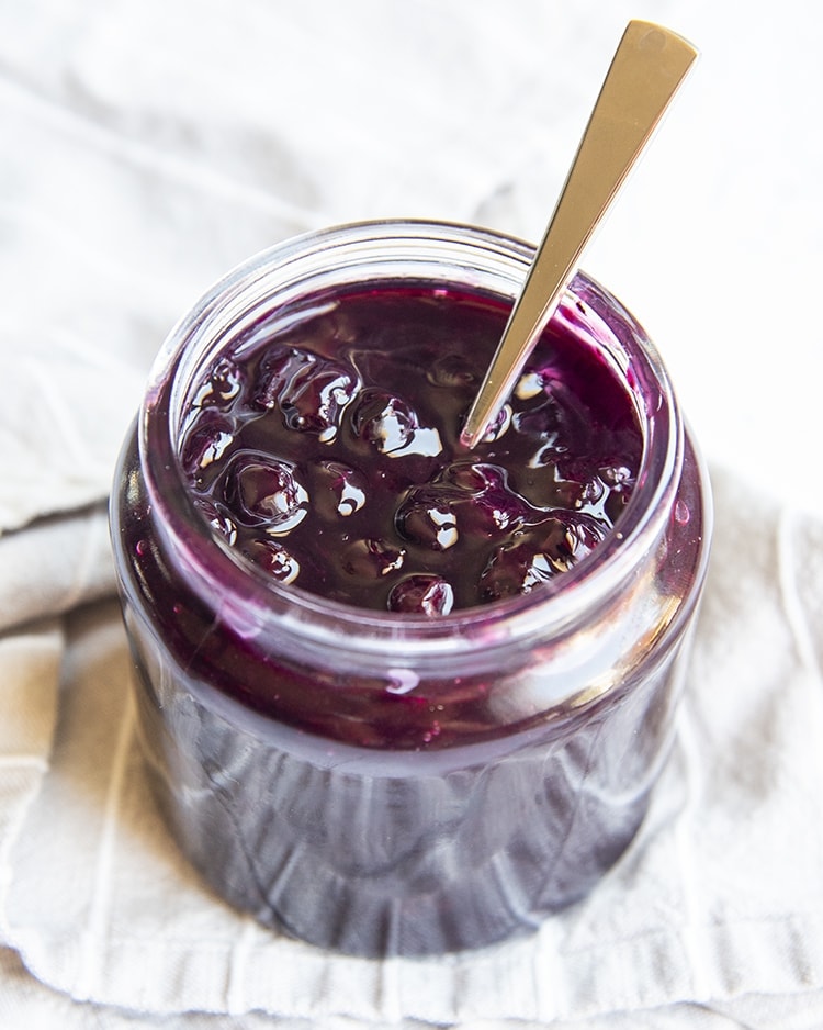 Blueberry topping in a jar with a spoon