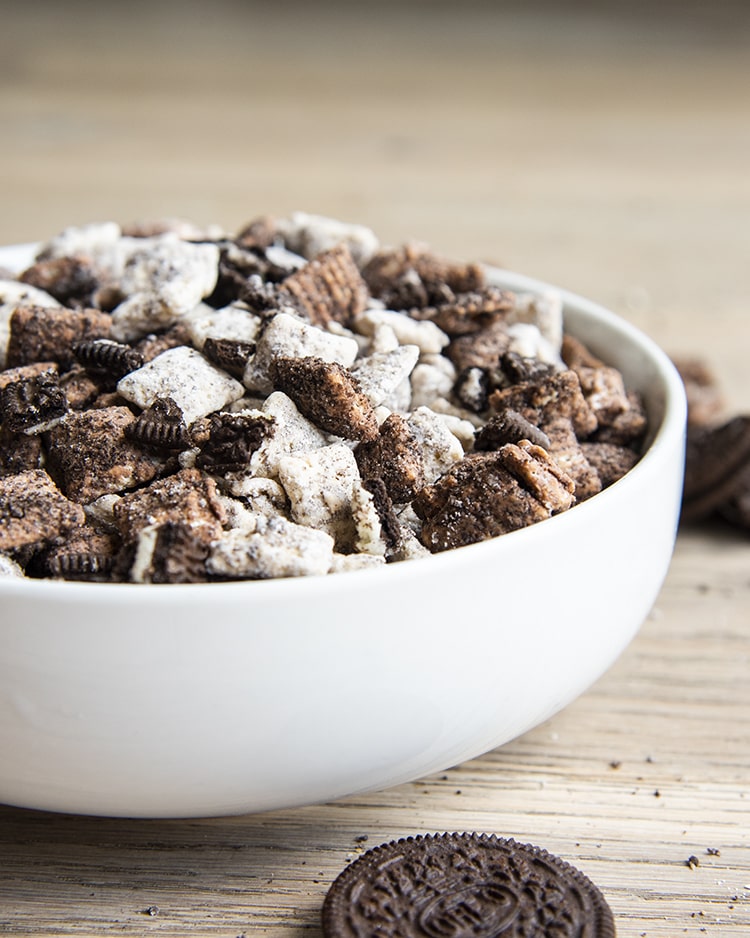 Cookies and cream muddy buddies with chex cereal and oreos in a white bowl.
