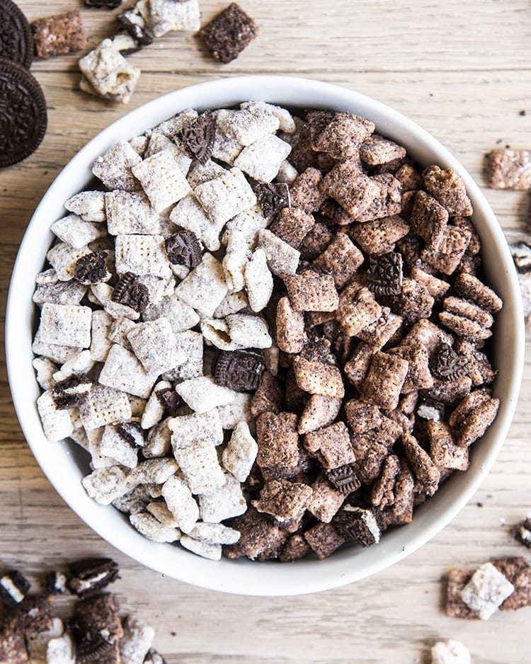 Cookies and cream muddy buddies with half made with white chocolate and half made with chocolate with oreo pieces