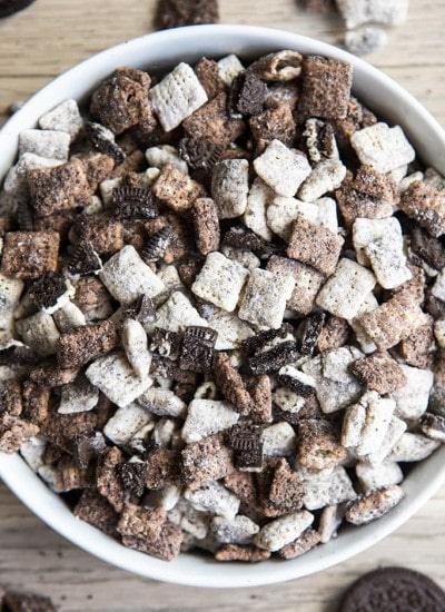 Cookies and cream muddy buddies with chex cereal and oreos in a white bowl.