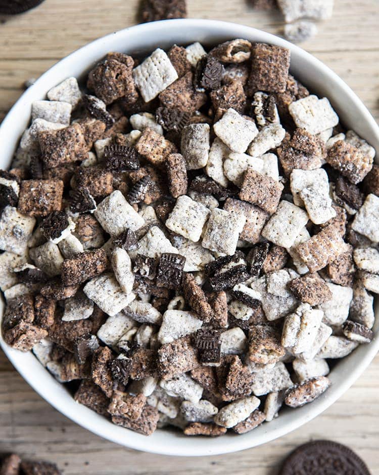 Cookies and cream muddy buddies with chex cereal and oreos in a white bowl.