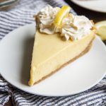 Lemon Cream Pie topped with whipped cream on a white plate